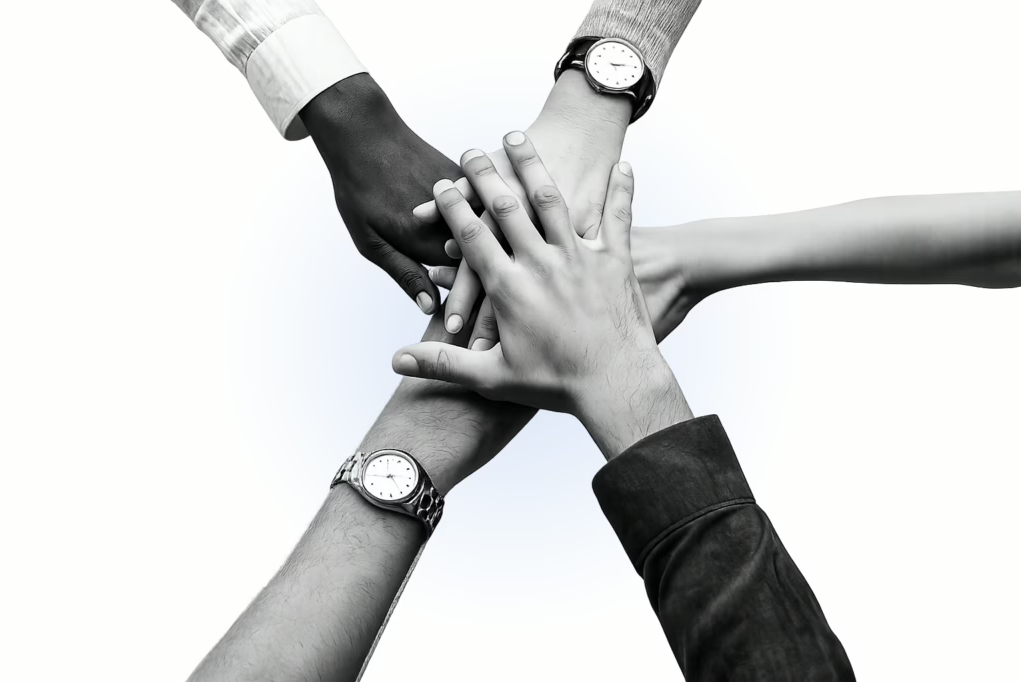Diverse team joining hands together